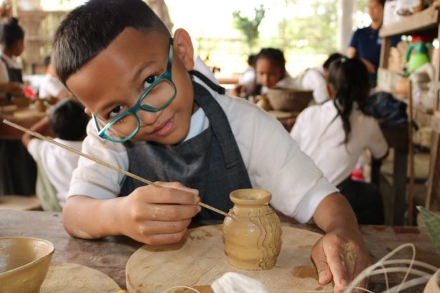 Child decorating pottery