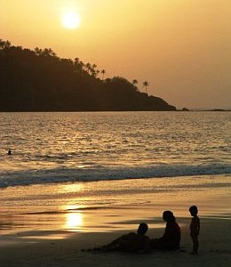 family-on-beach-as-sun-goes-down