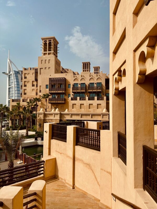 Traditional Arabic style buildings at Madinat Jumeirah with the Burj Al Arab hotel visible in the background in Dubai.