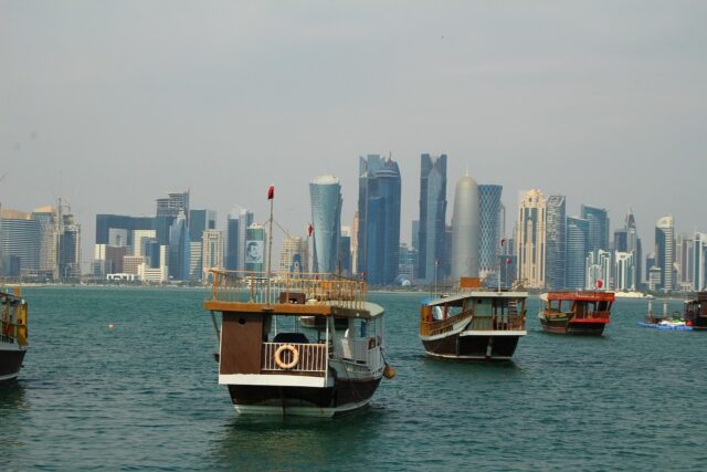 Skyline of Doha, Qatar with traditional dhow boats in the foreground, representing high-paying English teaching opportunities in Qatar.