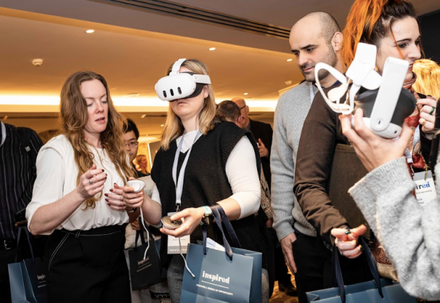 Teachers attending an Inspired careers event, exploring virtual reality technology with VR headsets and discussing opportunities in an education networking setting.