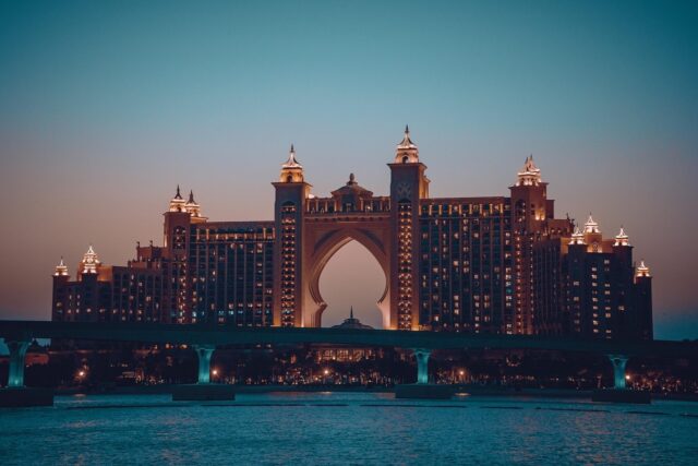 Atlantis, The Palm resort in Dubai lit up at dusk across the water.