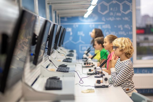 Young students collaborating at computers, exploring technology and science concepts.