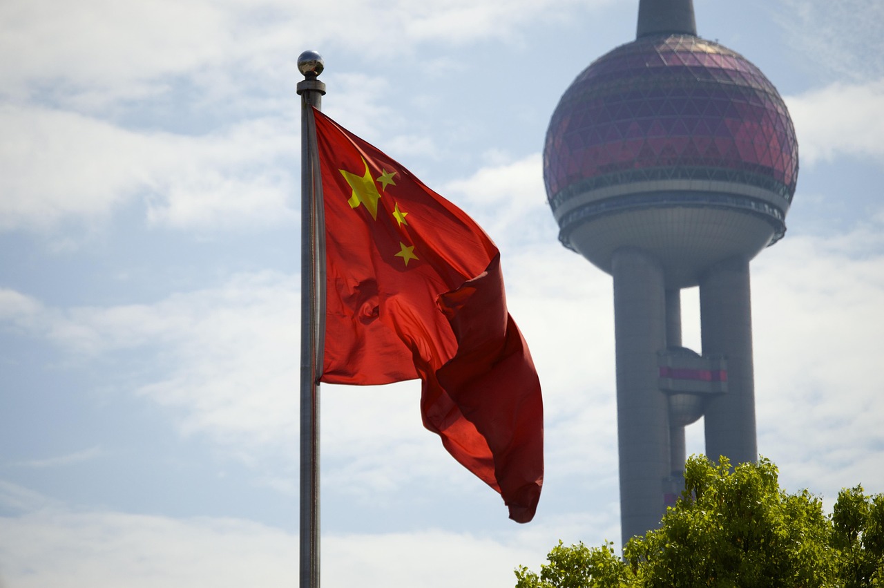 The Chinese national flag flying in front of the Oriental Pearl Tower in Shanghai