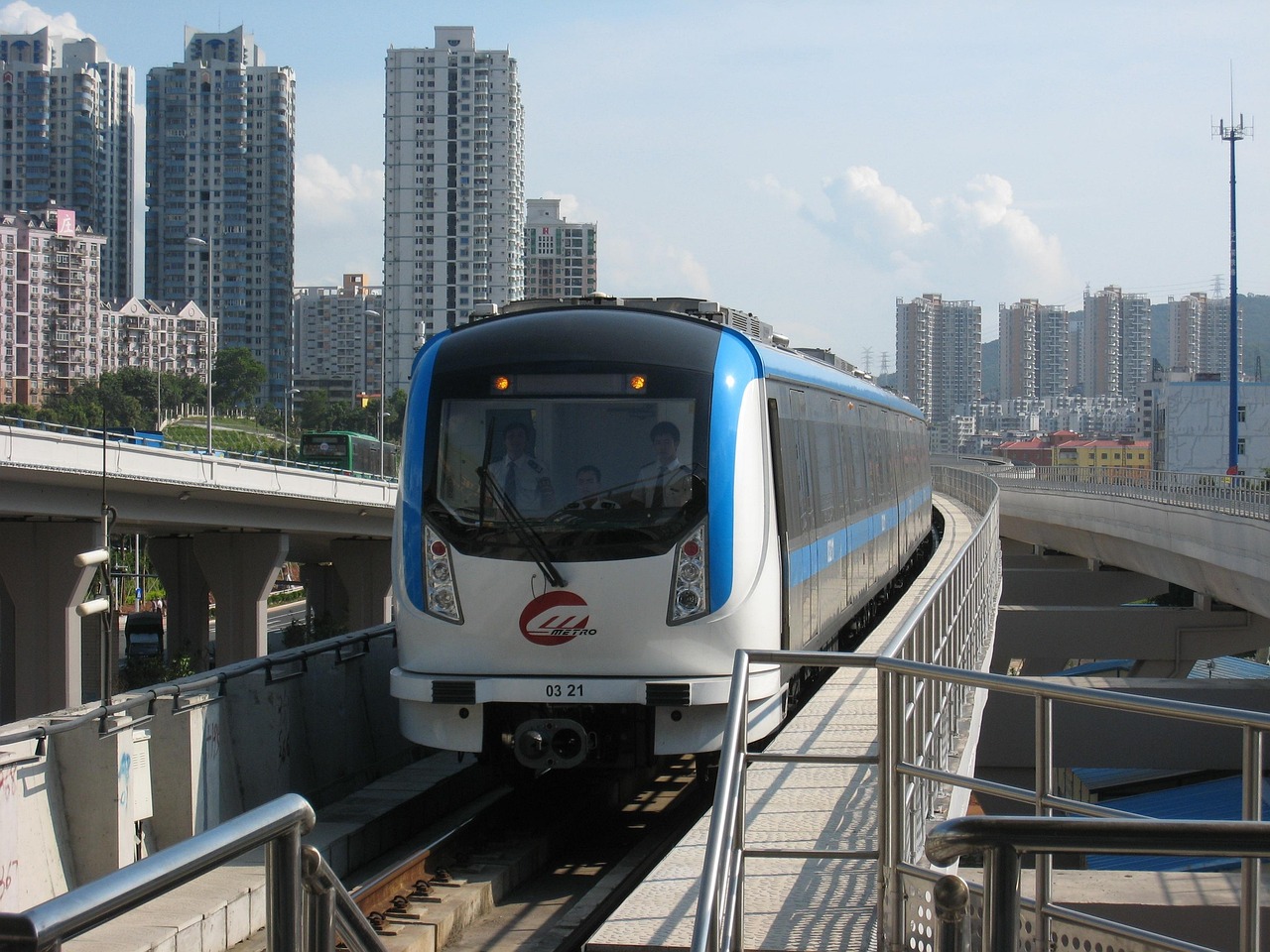 A sleek high-speed rail train on an elevated track in a modern Chinese city.